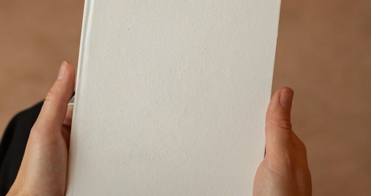 person holding notebook with blank page in hands