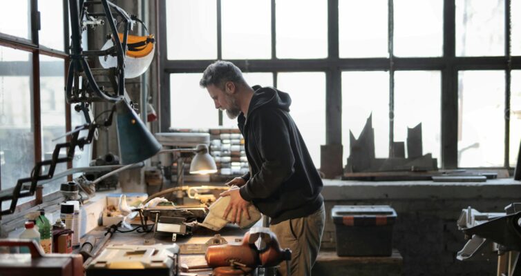 male master working with metal tools in garage