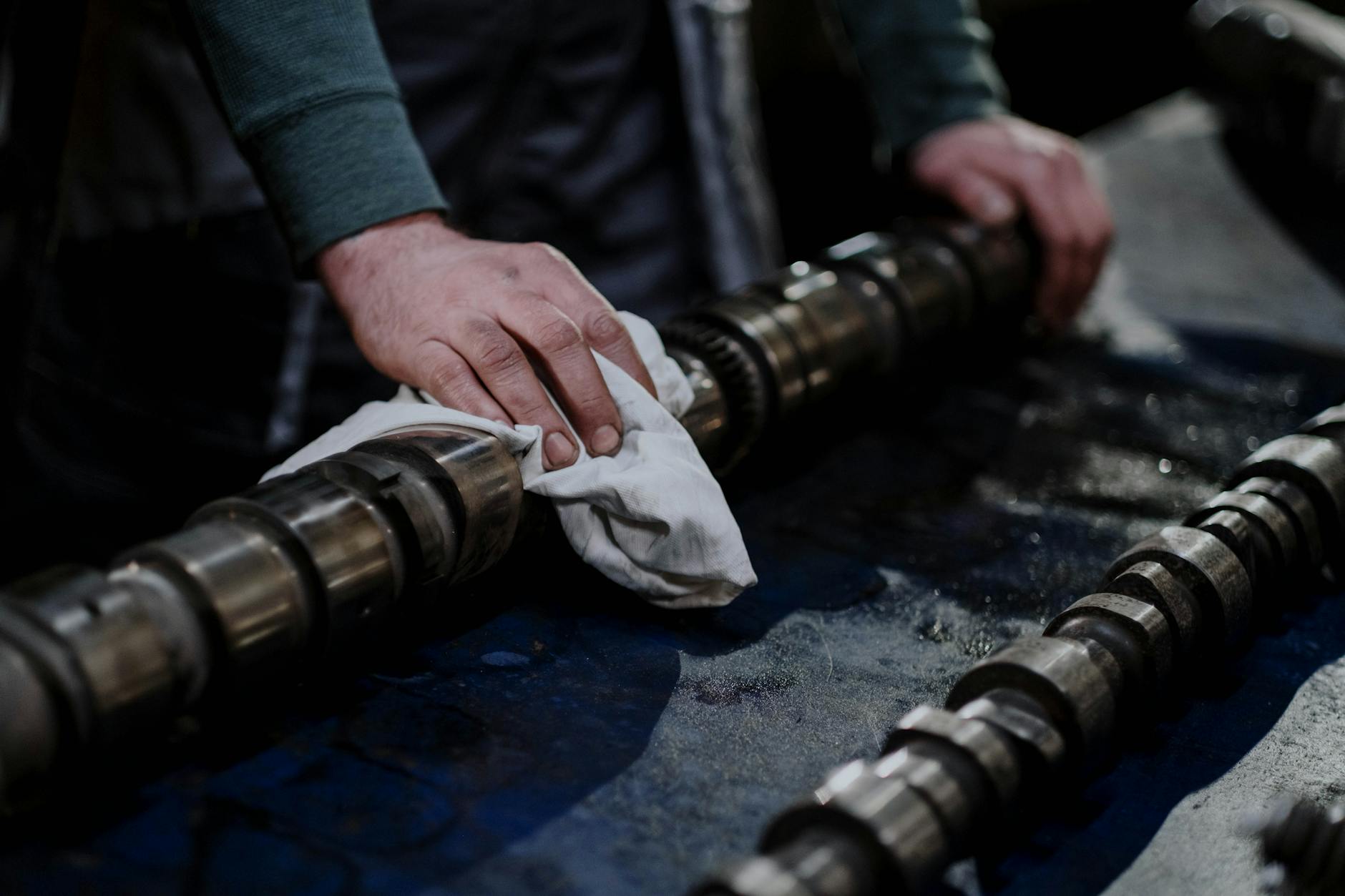 a person wiping a part of a metal engine