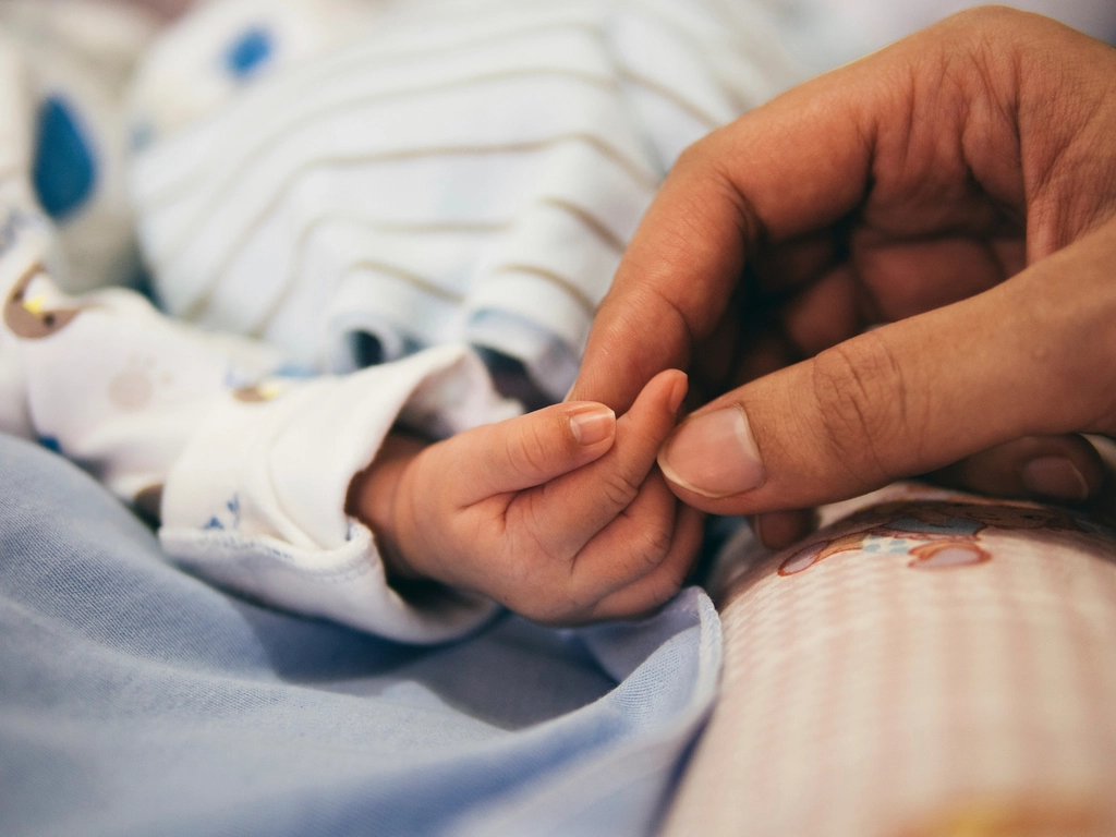 Mother holding hands new born